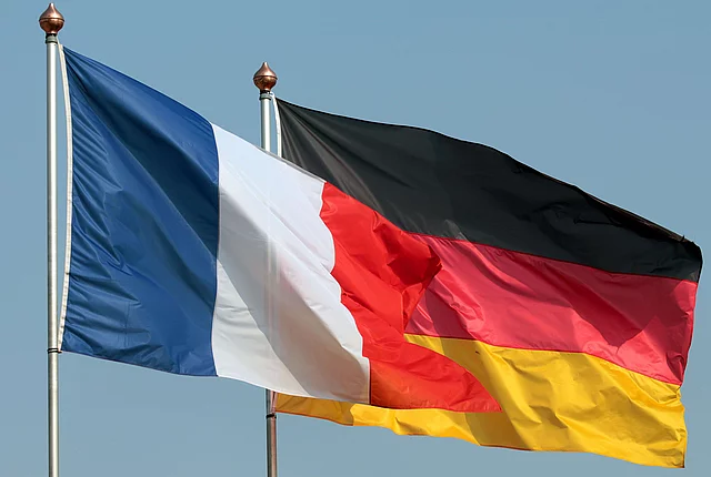 Flaggen Deutschlands und Frankreichs wehen einträchtig vor blauem Himmel...